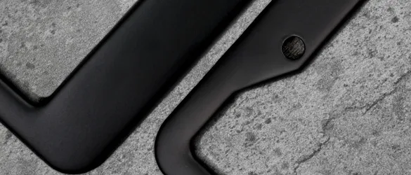 close up details of two black metal license plate frames