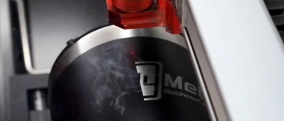 metal tumbler being etched by laser