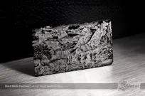 Entire card surface silver laser etched on a matte black metal business card